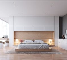 a modern bedroom with white walls and flooring is pictured in this image, there is a bed that has two lamps on either side of the headboard