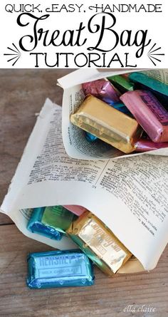 an open book sitting on top of a wooden table next to some candy bar wrappers