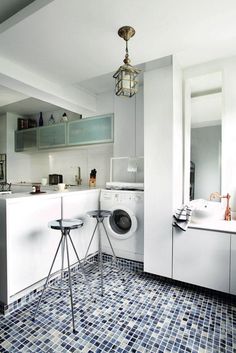 a washer and dryer sitting in a kitchen next to a counter with stools