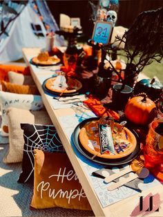 a table set up with halloween decorations and plates