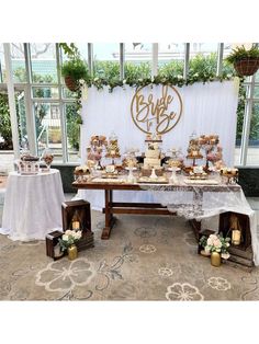 a table topped with lots of cakes and desserts next to a big sign that says bridal