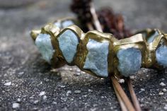 Inspired by the many shades and textures of the sea; Aquamarine are embedded in brass to create one of Emilie's signature styles. This bracelet is available in three different sizes and is not adjustable. Height 1" Diameter 2 1/2" - 3" Bracelet Opening 1" This piece is handmade-to-order, please allow 1 - 2 weeks to ship unless this piece is in stock. Each piece will vary slightly due to the uniqueness of the stones. All metal is nickel free. Signature Styles, Nyc Studio, Wax Carving, Jewelry Workshop, Cluster Necklace, Recycled Metal, Women Artisans, Craft Fairs, Signature Style