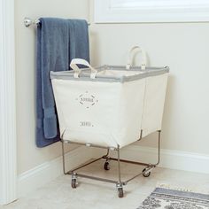 a laundry hamper sitting on top of a metal rack next to a blue towel