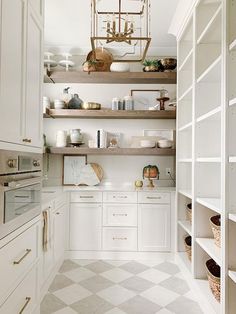 an image of a kitchen with white cabinets and open shelvings on the wall