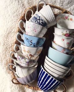 a basket filled with lots of cups and saucers