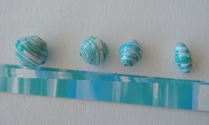 three seashells are lined up next to each other on a white surface with blue and green stripes