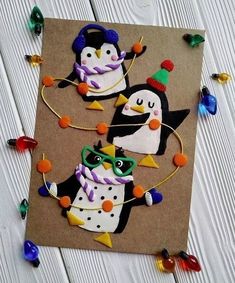 two decorated penguins are sitting on a piece of brown paper