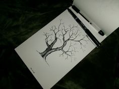 a drawing of a tree with no leaves on it next to a pen and paper