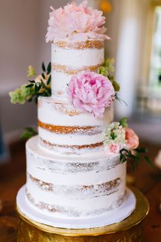 a three tiered cake with flowers on top