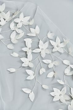 white flowers and pearls are on the fabric