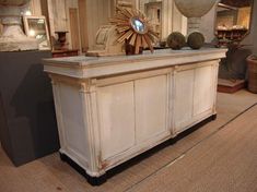 an antique white cabinet with decorative items on top