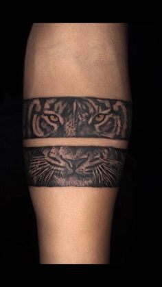 a man's leg with a tiger tattoo on the side of his thigh and an armband