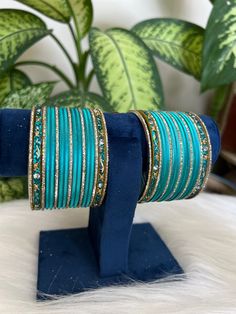 The perfect accessory for your special occasions, these  firoji   and golden Color Bangles feature Pearl and Stone detailing. Crafted with copper, these bangles are sure to add a touch of elegance and glamour to your look. Features: * Copper material *  Stone detailing *   firoji  and golden Color * Size: 2.6,2.8,2.10 Blue Traditional Bangle For Festive Occasions, Blue Bangle For Weddings And Festivals, Traditional Blue Bangle For Weddings, Blue Wedding Bangle For Festive Occasions, Traditional Blue Wedding Bangle, Blue Festive Wedding Bangle, Festive Blue Wedding Bangle, Green Zari Work Bangle Bracelet, Festive Blue Bangle Jewelry