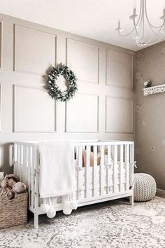 a baby's room with a white crib, teddy bears and a wreath on the wall