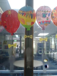 there are many balloons in the window with writing on them and some stickers attached to it