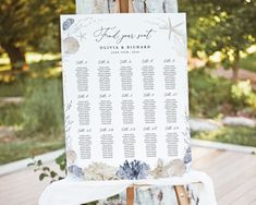 an easel with a seating chart on it sitting in front of a wooden deck