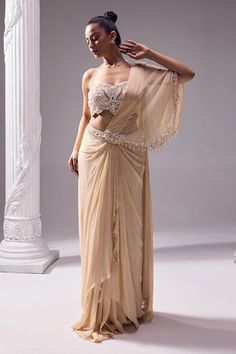 Pale beige asymmetric draped saree with bead, crystal, cutdana embroidery on pallu. Paired with halter neck beaded strap blouse. - Aza Fashions Beige Pre-draped Saree, Elegant Beige Blouse Piece With Traditional Drape, Elegant Beige Blouse With Traditional Drape, Beige Saree, Solid Saree, Crepe Saree, Saree Gown, Drape Saree, White Saree