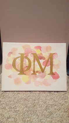 a painted sign with the letter dm in gold foil on it's side