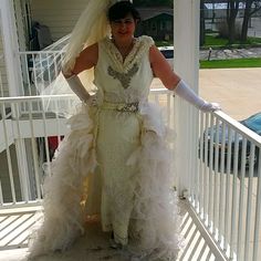 a woman in a wedding dress standing on a porch