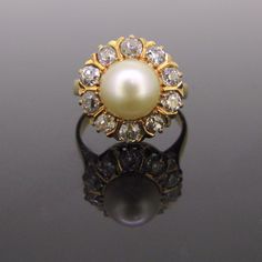 Weight: 6gr Metal:18kt yellow gold  Stones:1 Cultured Pearl *Diameter:8.74mm x 8.73mm   Others:10 old cut diamonds *Total carat weight:1ct approximately *Cut:I/J *Colour:SI Condition:Very Good  Comments:This ring is fully made in 18kt yellow gold. It is set in its centre with a creamy cultured pearl surrounded by 10 old cut diamonds with an approximate total carat weight of 1ct. The ring is not marked and it has been tested 18kt gold.  Pearl symbolises purity and innocence; they are usually wear Pearl Rings Vintage, Cultured Pearl Ring, Gold Pearl Ring, Gold Bridal Jewellery Sets, Pearl And Diamond Ring, Gold Earrings Designs, Diamond Cluster Ring, Diamond Cluster, Gold Pearl