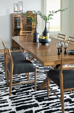 a dining room table with chairs and vases on it