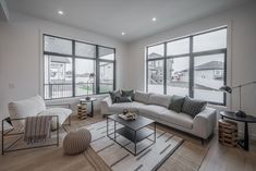 a living room filled with furniture and large windows