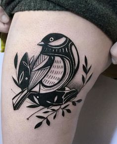 a black and white bird tattoo on the thigh