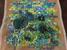 there is a piece of art made out of cloths and beads on the table