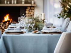 the table is set with white dishes and place settings