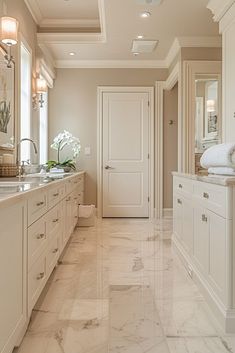 a large bathroom with marble flooring and white cabinetry, along with two sinks