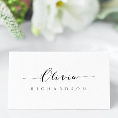 a white business card with the name elira on it and flowers in the background