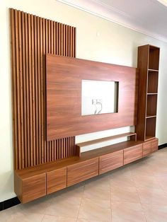 a large wooden entertainment center in a living room with tile flooring and white walls