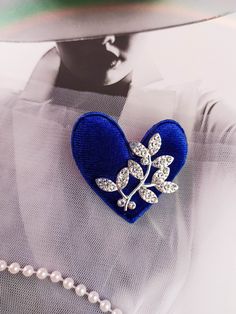 This brooch is a symbol of love in an elegant style. Whether you're dressing up a casual ensemble or adding a final touch to your formal attire, this brooch is a versatile accessory that exudes charm and personality. The combination of the blue tone and the shimmering twig creates a harmonious blend of nature-inspired beauty and modern chic. This heart is light and soft. The corduroy material on the outside lends a soft and velvety texture. The size of the brooch is 1.77 inches * 1.77 inches (4. Cheap Blue Brooch Jewelry, Luxury Heart-shaped Brooches For Formal Wear, Luxury Elegant Heart Brooches, Luxury Heart-shaped Brooches For Formal Occasions, Luxury Heart-shaped Brooch, Corduroy Material, Symbol Of Love, Everyday Elegance, Blue Tone