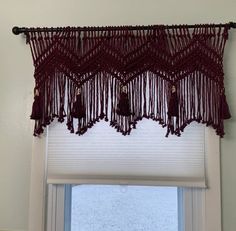 a red curtain hanging from the side of a window next to a window sill