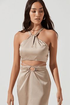 This item is Final Sale The Robin Halter Crop Top in Khaki is our favorite going-out top. Featuring a luxurious satin material, halter neckline, ruched neck, and open back detailing, it is sleek and sophisticated yet sultry. Pair with the matching Robin Midi Skirt or dress it down with jeans to turn heads regardless of the dress code on your next night out.  Composition & Fit Halter Neckline Cropped Length Tie Back Detail Wrap Top Blouse, Tie Waist Top, Satin Crop Top, White Sleeveless Blouse, Astr The Label, Satin Color, Halter Crop Top, Flutter Sleeve Top, Puff Sleeve Top