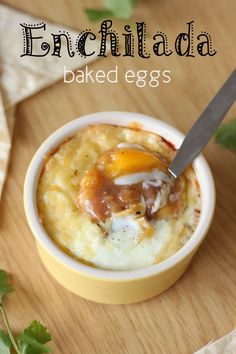 a small bowl filled with baked eggs on top of a wooden table