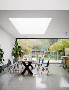 a dining room filled with lots of tables and chairs next to large windows that look out onto the backyard