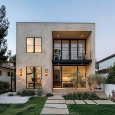 an exterior view of a modern home with grass and steps leading up to the front door