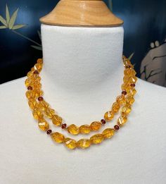 This 18" strand of faceted citrine nugget beads is the perfect way to bring a little sunshine into your life! With bright golden amber body color and rich orange patterning inside the crystals that resembles flowing honeycomb, this necklace is both beautiful and fun! Each citrine bead has a "swirled diamond" shape and slender rectangular facets that allow the light to reflect from all directions. Pomegranate red garnet rondels add pops of color, while the 14k yellow gold spacers and "S" clasp pi Gold Citrine Necklaces With Gemstone Beads, Formal Faceted Citrine Necklaces, Gold Citrine Gemstone Beads Necklaces, Citrine Beaded Necklace, Amber Citrine Beaded Necklace, Golden Amber, Red Pomegranate, Citrine Beads, Body Colour