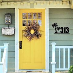 a yellow front door with a wreath on it