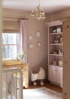 a baby's room with pink walls and furniture