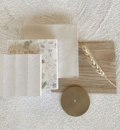 various materials are laid out on a white surface, including tiles and a candle holder