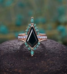 an image of a black stone ring on top of a piece of rock with blue and white stones