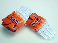 two orange and white gloves sitting on top of each other