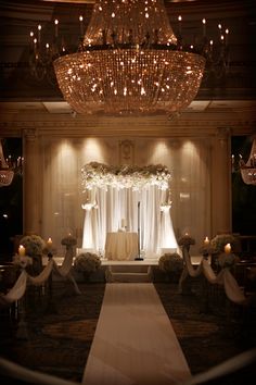 an elegant wedding setup with chandeliers and flowers