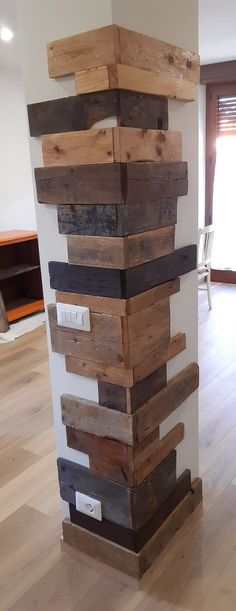 a tall stack of wooden planks on top of a hard wood floor in an empty room