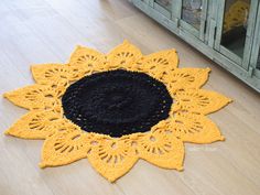 a black and yellow doily is on the floor