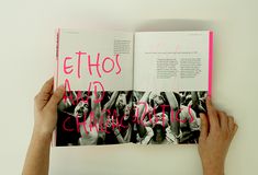 a person holding up a book with pink writing on the front and back pages that read ethos and annotates