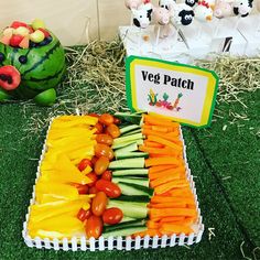 a tray filled with cut up veggies on top of grass next to other vegetables