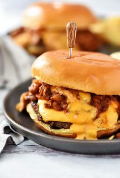 a cheeseburger on a black plate with fries